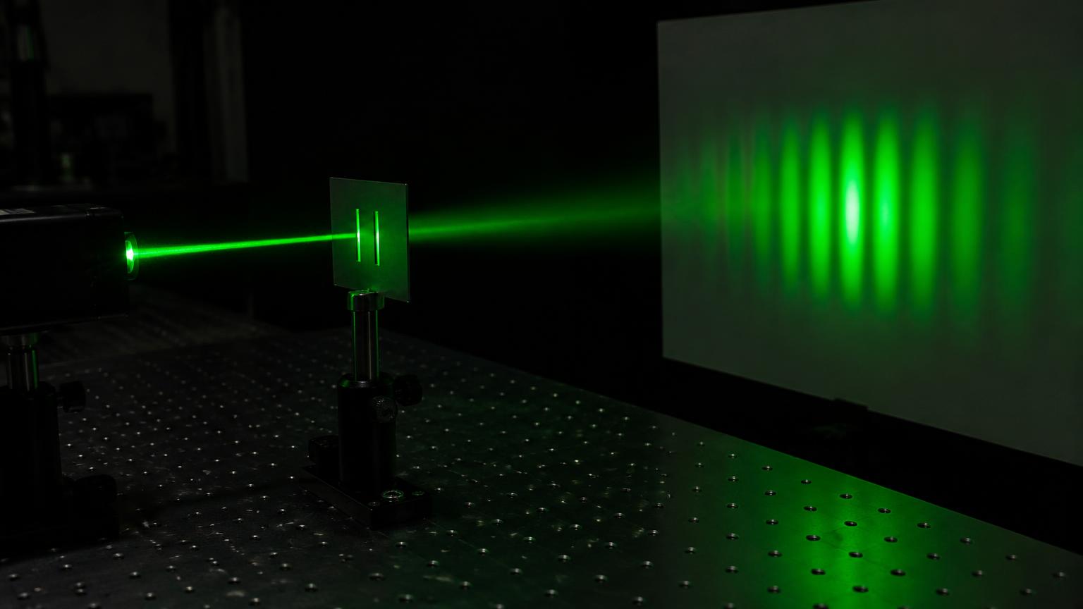 Laser verde passando por fenda dupla e formando faixas de interferência na tela