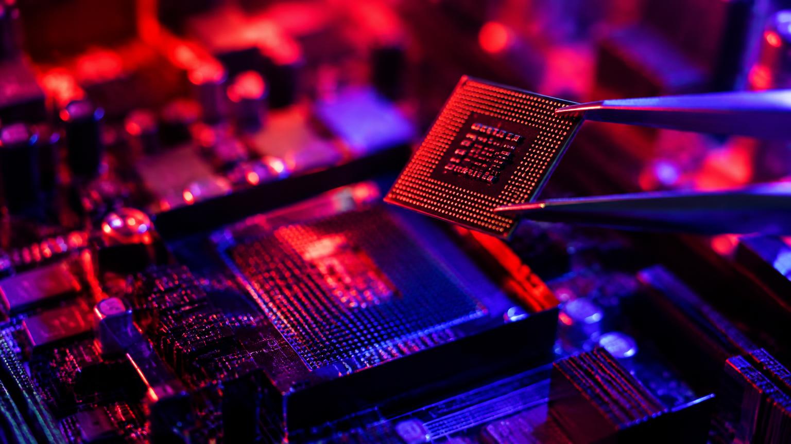 Chip sendo encaixado com pinça sob luz vermelha e roxa